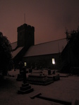 SX25885 Snow covered OId St Illtud's Church with lights on Llantwit Major.jpg
